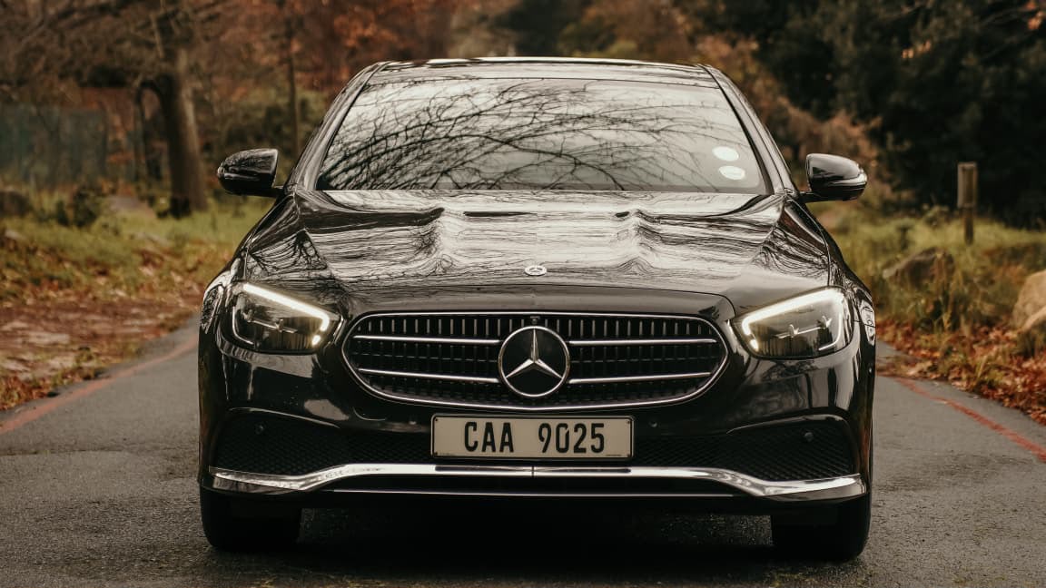 Black Mercedes sedan on a wooded road — Cape Luxury Chauffeur