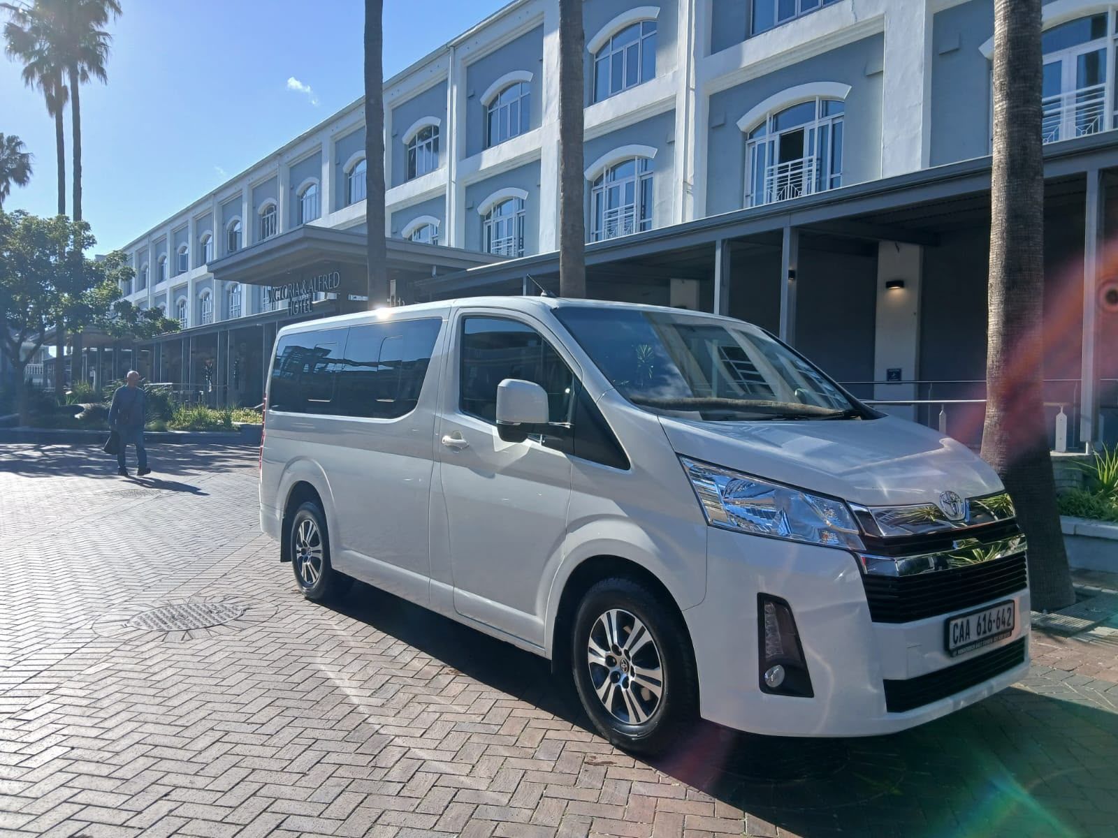 White passenger van parked outside an upscale hotel